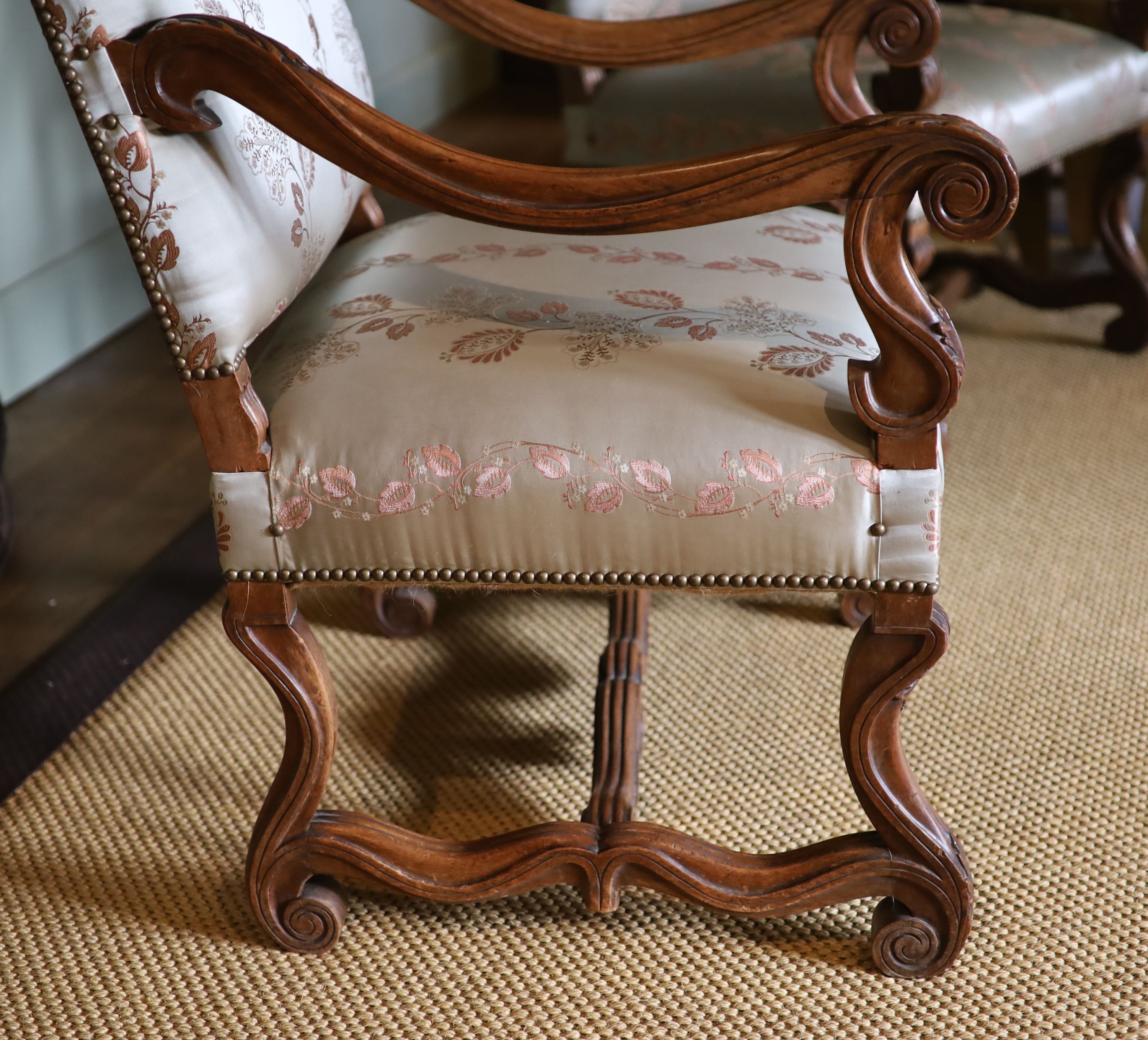 A pair of French carved walnut fauteuils, with machine embroidered Eau de Nil silk upholstery, width 66cm height 106cm